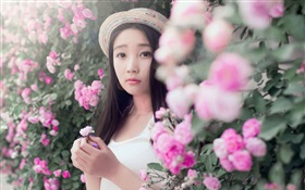 Asiatisches Mädchen mit rosafarbenen Blumen