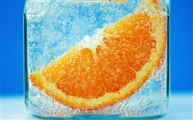 Orange Scheiben im Wasser, blauer Hintergrund, Blase