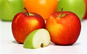 Zwei rote Äpfel, grüner Apfel in Scheiben schneiden, schmackhafte Früchte