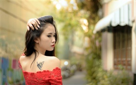 Asiatisches Mädchen, Tätowierung, rotes Kleid, zurückblicken