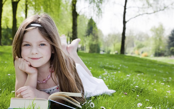 Nettes kleines Mädchen im Gras, lesen Buch Hintergrundbilder Bilder